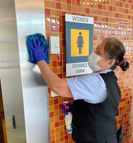 Cleaning team member wiping down high-touch surfaces at the airport