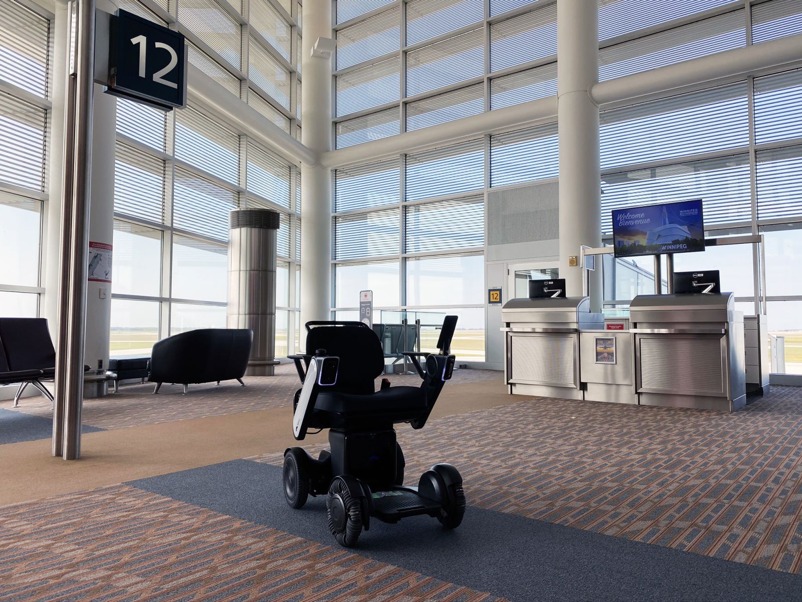 WHILL personal autonomous mobility device stationed near gate 12 at YWG