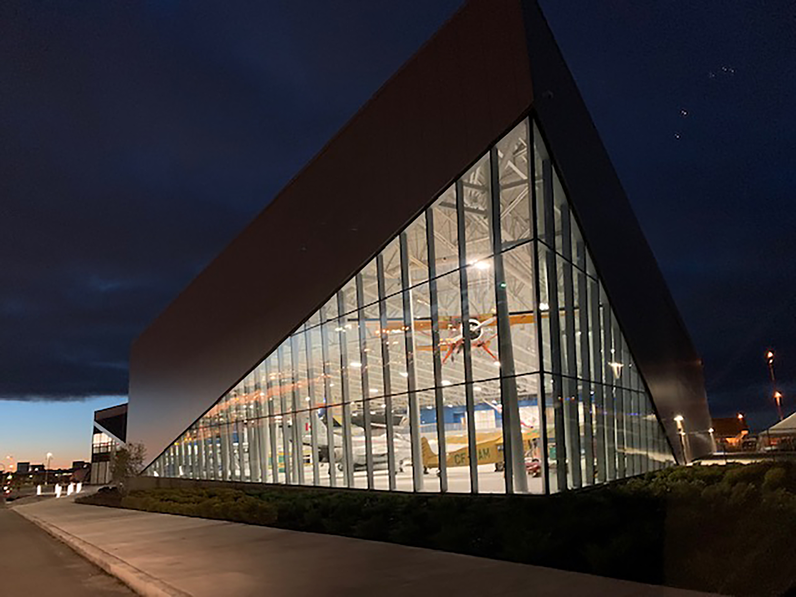 Royal Aviation Museum of Western Canada captured at night with aircraft shining inside.