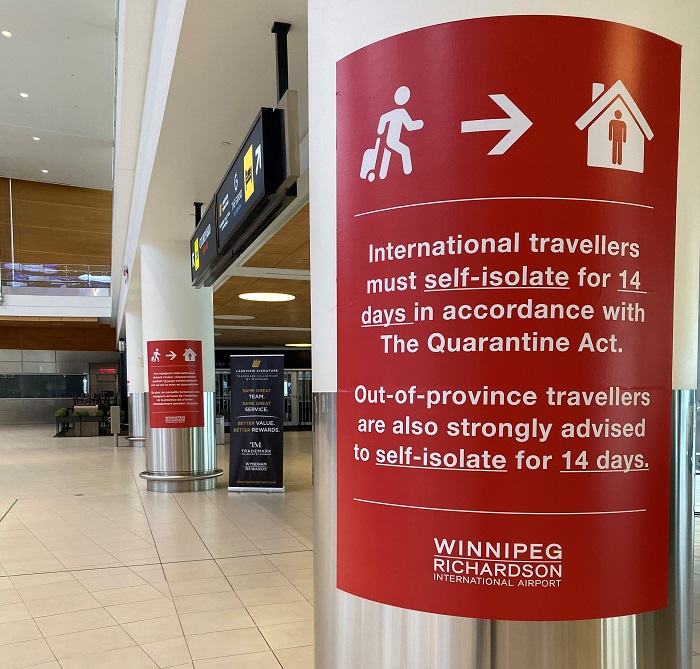Self-isolation signage on a pillar in the Arrivals Hall