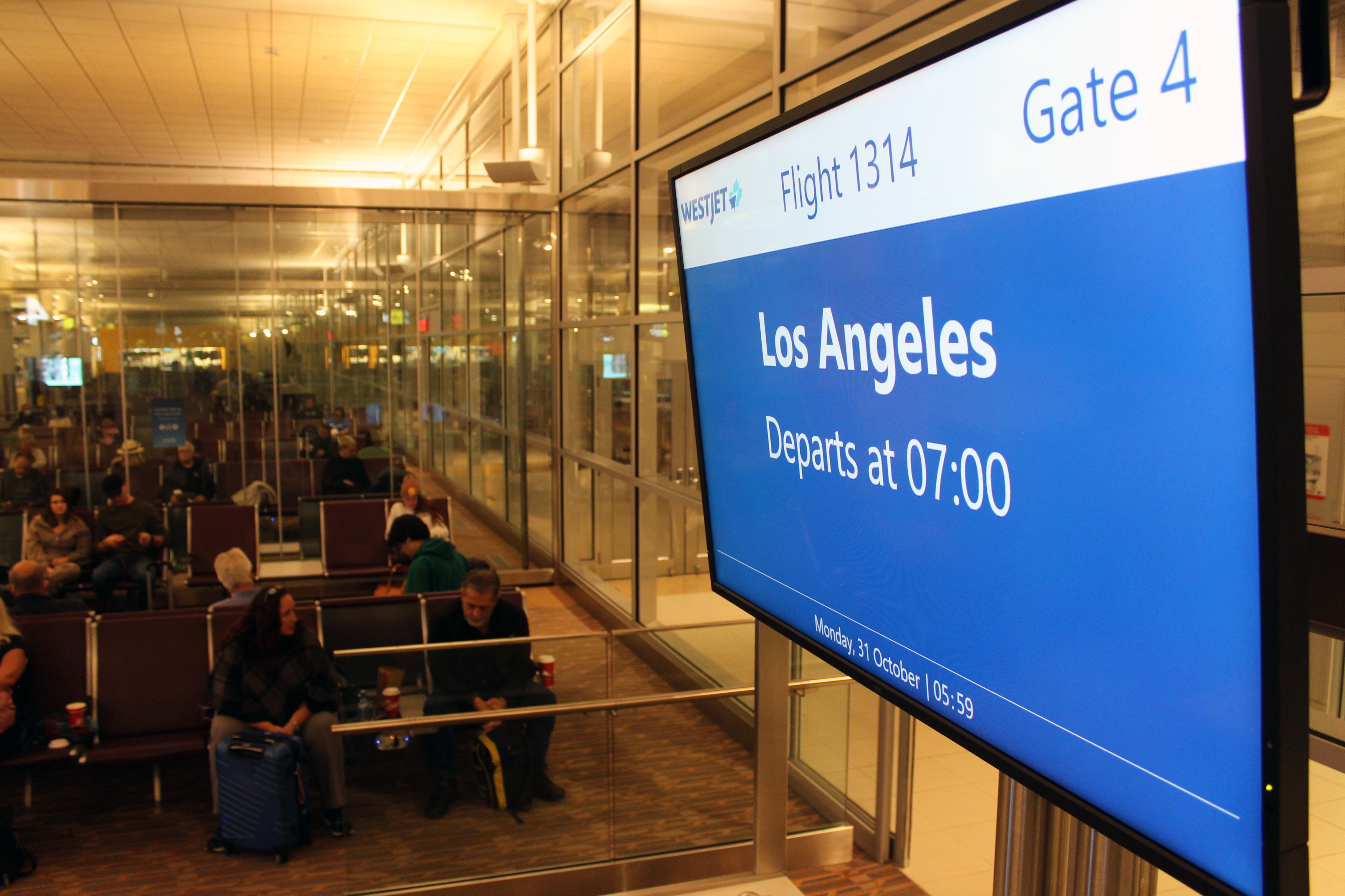 Los Angeles is shown on the flight information screen above the Gate 4 check-in counter at Winnipeg Richardson International Airport.