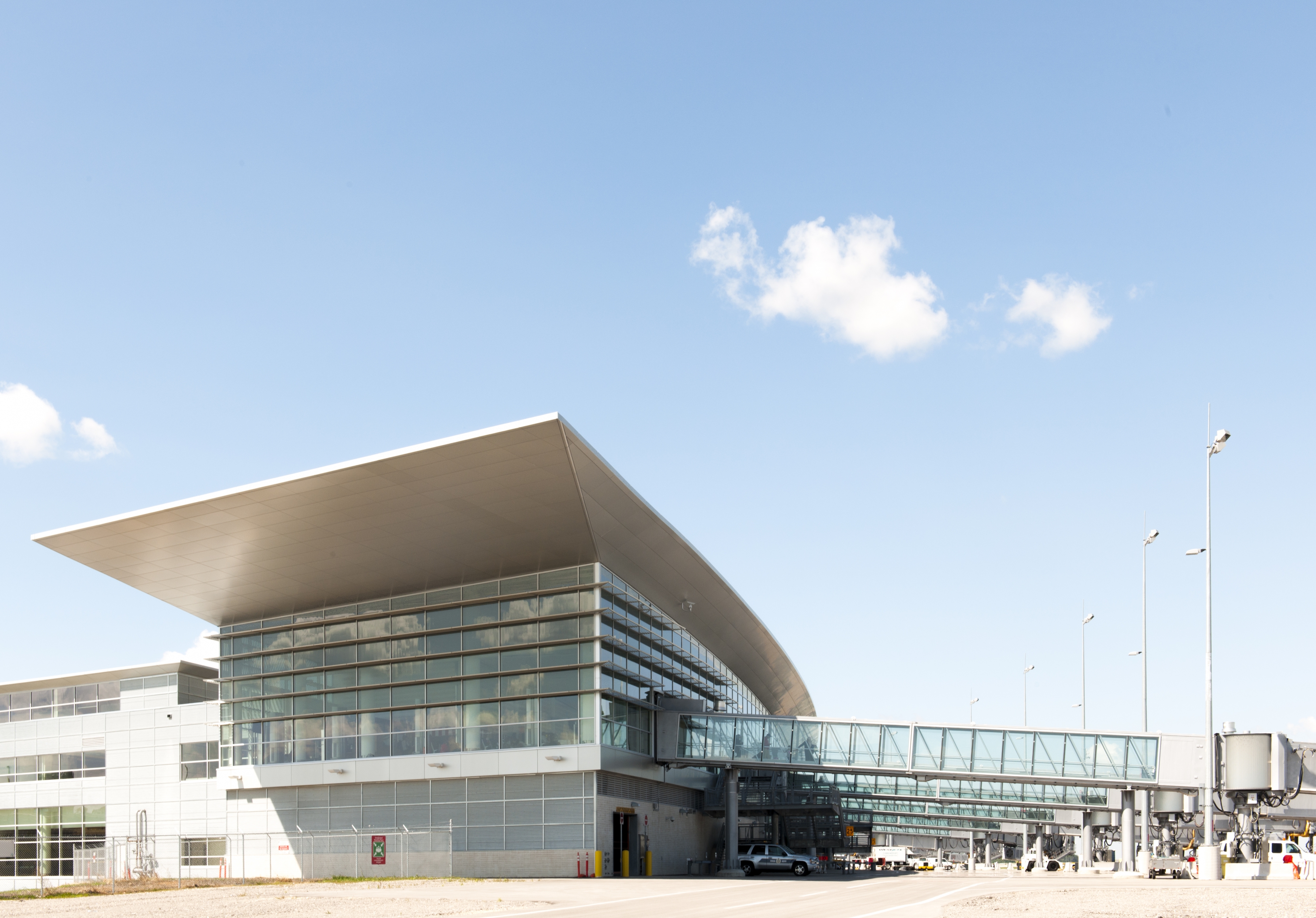 Exterior photo of the airport in the summer with five bridges in view.