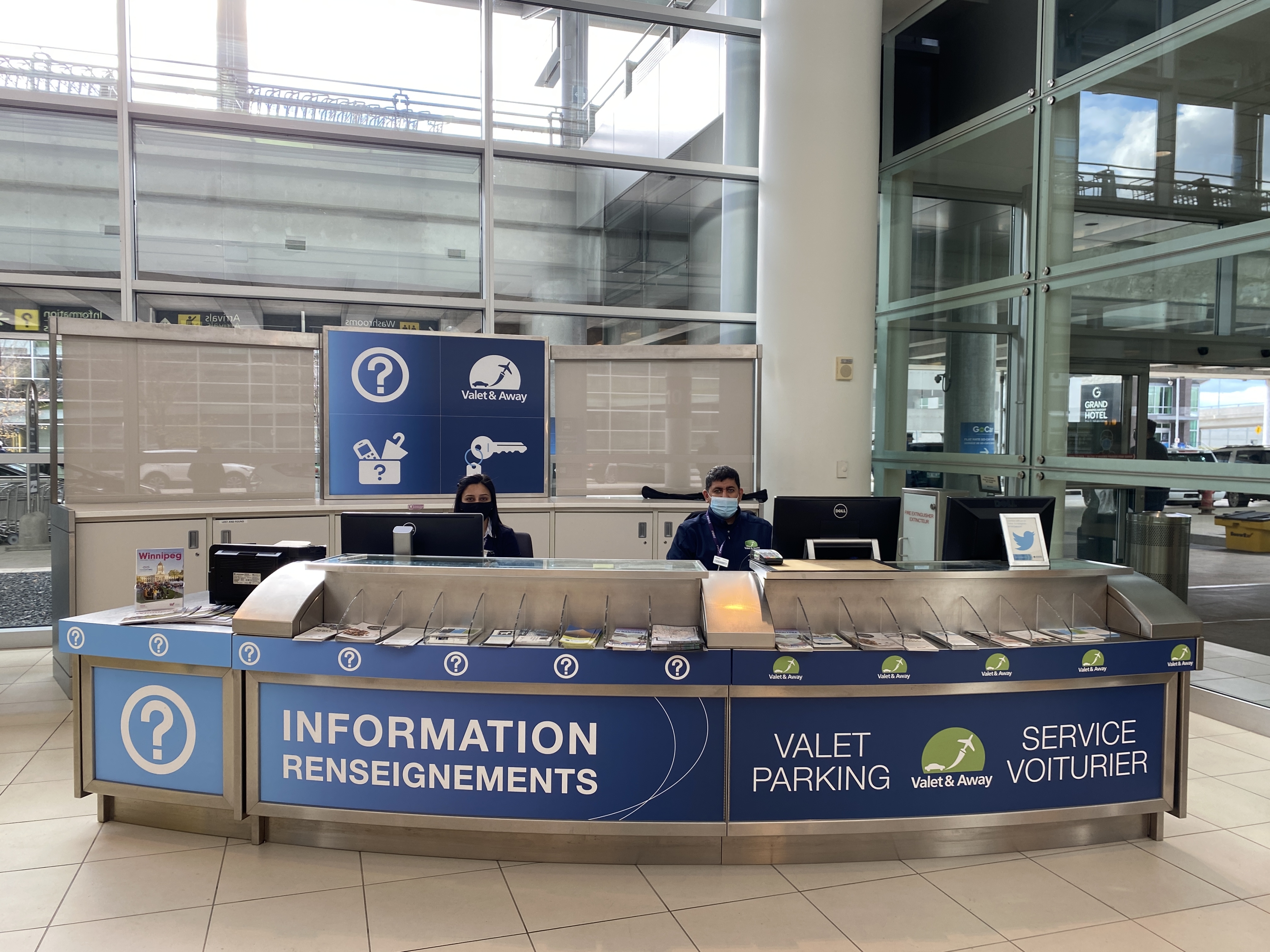 A large blue and white booth with an Information Booth team member at the desk.